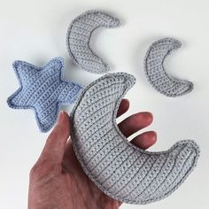 someone is holding two knitted stars and a crescent