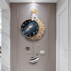 a wall clock with an astronaut on the moon hanging from it's side in a hallway