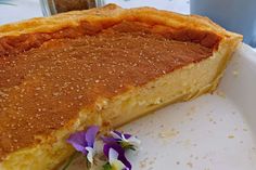 a close up of a pie on a plate with flowers in the middle and one slice missing