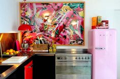 a pink refrigerator freezer sitting inside of a kitchen next to a stove top oven