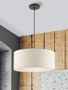 a white lamp hanging from the ceiling in a room with wood paneling on the wall