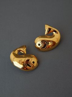 Vintage TRIFARI Whale Fish Earrings Clip-Ons, Gold Tone Fish Earrings, Embossed Gold Whale Earrings, Nautical Beach Jewelry, Estate Jewelry♥ Very rare and hard to find collectible vintage modernist Trifari earrings featuring large fish or whales in a highly polished gold plated finish with embossed designs and cut-out accents. A fun pair of earrings to wear in any season! They will make a great addition to your collection or an excellent gift!♥ Non-pierced earrings with clips in the back♥ Hallma Whale Earrings, Gold Whale, Whale Fish, Fish Earrings, Vintage Trifari, Gold Fish, Pierced Earrings, Beach Jewelry, Jewelry Vintage