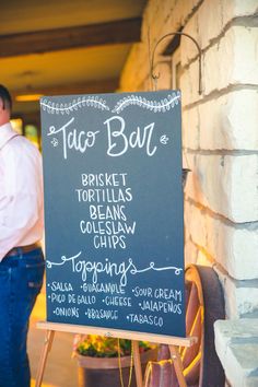 a man standing next to a chalk board sign