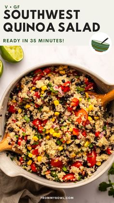 a bowl filled with rice and vegetables on top of a white table next to limes