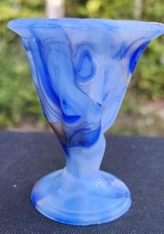 a blue glass vase sitting on top of a table