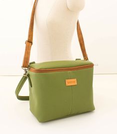 a female mannequin holding a green purse