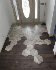 an entryway with wood flooring and stained glass windows on the door way to another room