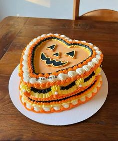 a heart shaped cake decorated with pumpkins and jack - o'- lantern decorations