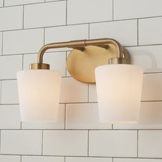 a bathroom light that is on the wall next to a brick wall with white tiles