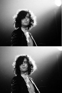 black and white photograph of a man with long hair in front of a microphone on stage