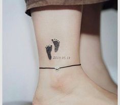 a small ankle tattoo with footprints on the foot and numbers tattooed on it's side