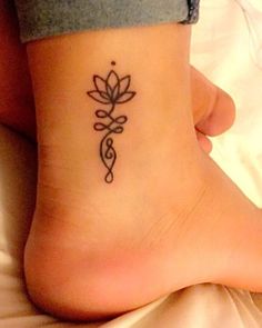 a woman's foot with a small tattoo on the side of her leg and a flower