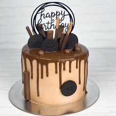 a birthday cake with chocolate icing and oreo cookies