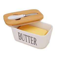 a butter knife in a white container with a wooden handle and yellow sticky pad inside