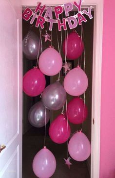 pink and grey balloons are hanging from the door