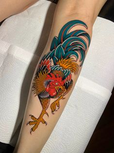 a woman's leg with a rooster tattoo on it