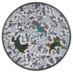 a white plate with blue and green designs on it's sides, in the shape of animals