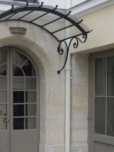 the front entrance to a building with two doors and an awning over it's doorway