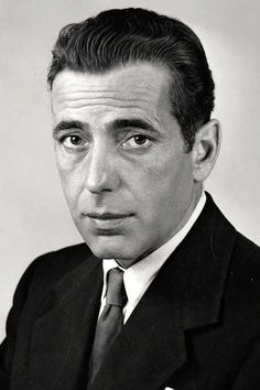 a black and white photo of a man in a suit with a serious look on his face