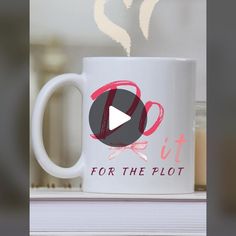 a white coffee mug with the words for the plot on it and a pink ribbon