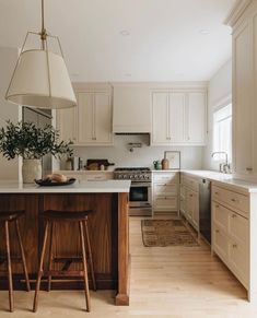 a kitchen with white cabinets and wooden stools