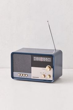 an old fashioned radio sitting on top of a white table next to a gray wall