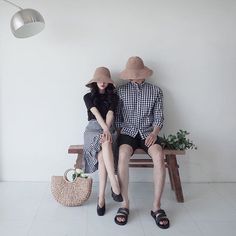 two people sitting on a bench wearing hats