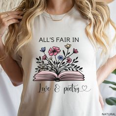 All's Fair In Love & Poetry Shirt, Love and Poetry T-shirt, Book with Flowers, Taylor Fan Shirt, Music Lover Shirt, Gift for Daughter Mom This classic unisex jersey short sleeve tee fits like a well-loved favorite. Soft cotton and quality print make users fall in love with it over and over again. These t-shirts have-ribbed knit collars to bolster shaping. The shoulders are tapered for a better fit over time. Dual side seams hold the garment's shape for longer.  .: Made with 100% Airlume combed a Bookish Short Sleeve T-shirt For Spring, Spring Bookish Short Sleeve T-shirt, Spring Bookish Short Sleeve Tops, Bookish Short Sleeve Tops For Spring, Spring Bookish Style Short Sleeve T-shirt, Spring Cotton T-shirt With Bookish Style, Spring Bookish T-shirt With Letter Print, Summer Bookish Tops With Letter Print, Bookish Style Letter Print Summer Tops