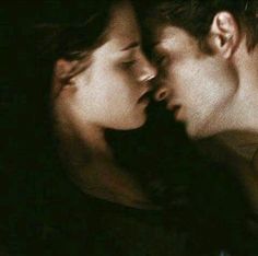 a man and woman kissing in the dark with their eyes close to each other's foreheads