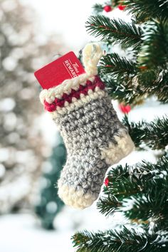 a knitted stocking hanging from a christmas tree