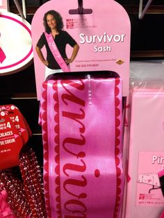 a pink ribbon with the word survivor sash on it and other items in front of it