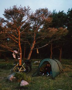 a person sitting in a tent next to a bike