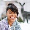 a woman is smiling in front of some deer