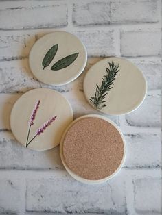 three coasters with plants on them sitting on a brick wall next to each other