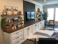 a living room filled with furniture and a flat screen tv on top of a wooden shelf