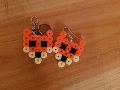 the earrings are made out of legos and have black, white, and orange beads