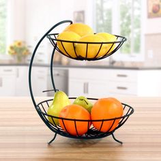 two metal baskets filled with fruit on top of a wooden table