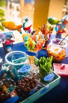 a table filled with candy and candies on top of a blue cloth covered table