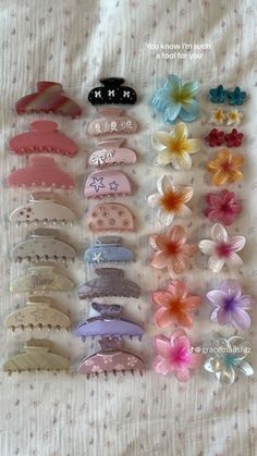 many different types of hair clips on a bed