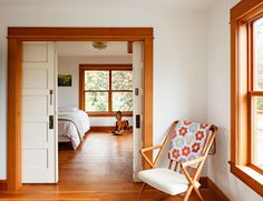 a chair sitting in the middle of a living room next to a door and window