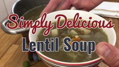 a person is holding a bowl of soup with the words simply delicious lentil soup