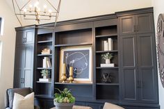 a living room with built in bookshelves and a potted plant on the table