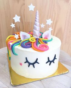 a birthday cake with white frosting and rainbow colored icing