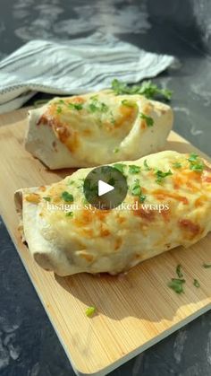 two cheesy breads sitting on top of a cutting board