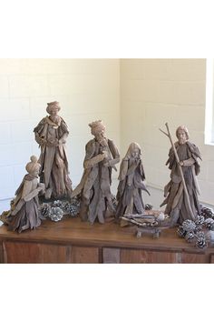 a group of figurines sitting on top of a wooden table next to each other