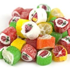 a pile of colorful candies with fruit on top