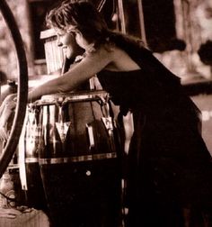 a woman standing next to a wine barrel