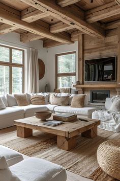 a living room filled with lots of white furniture and wooden beams on the ceiling, along with large windows