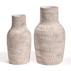 two white vases sitting next to each other on a white surface with lines drawn across them