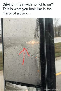 the red arrow is pointing to the left side of a bus window with rain drops on it